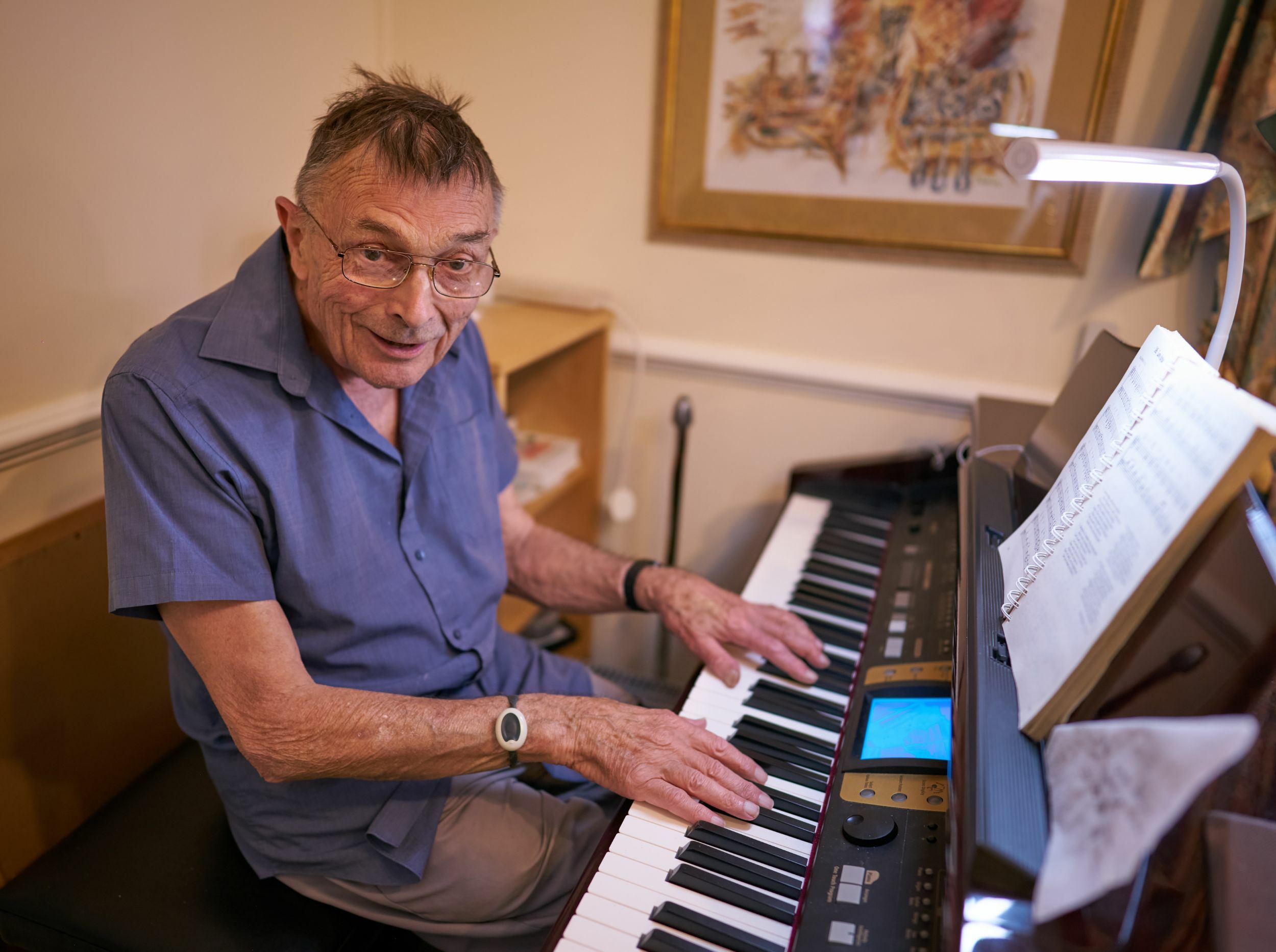 Senior resident playing the piano in a communal area
