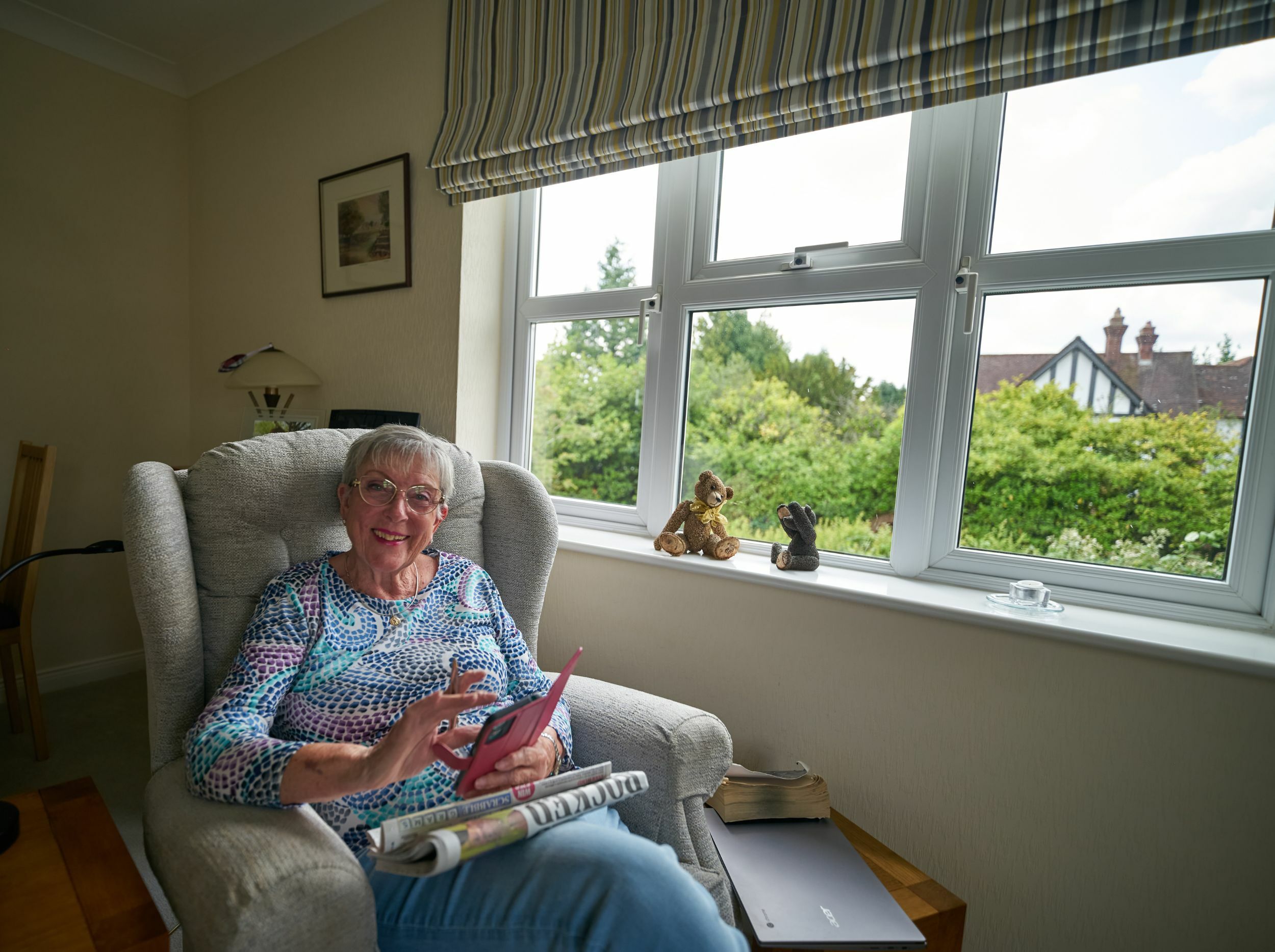 Resident enjoying a relaxing moment indoors with greenery outside.