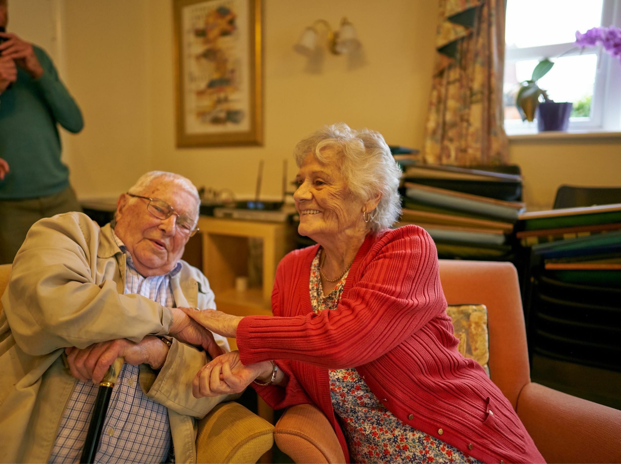 Two residents enjoying each other's company in a common area.