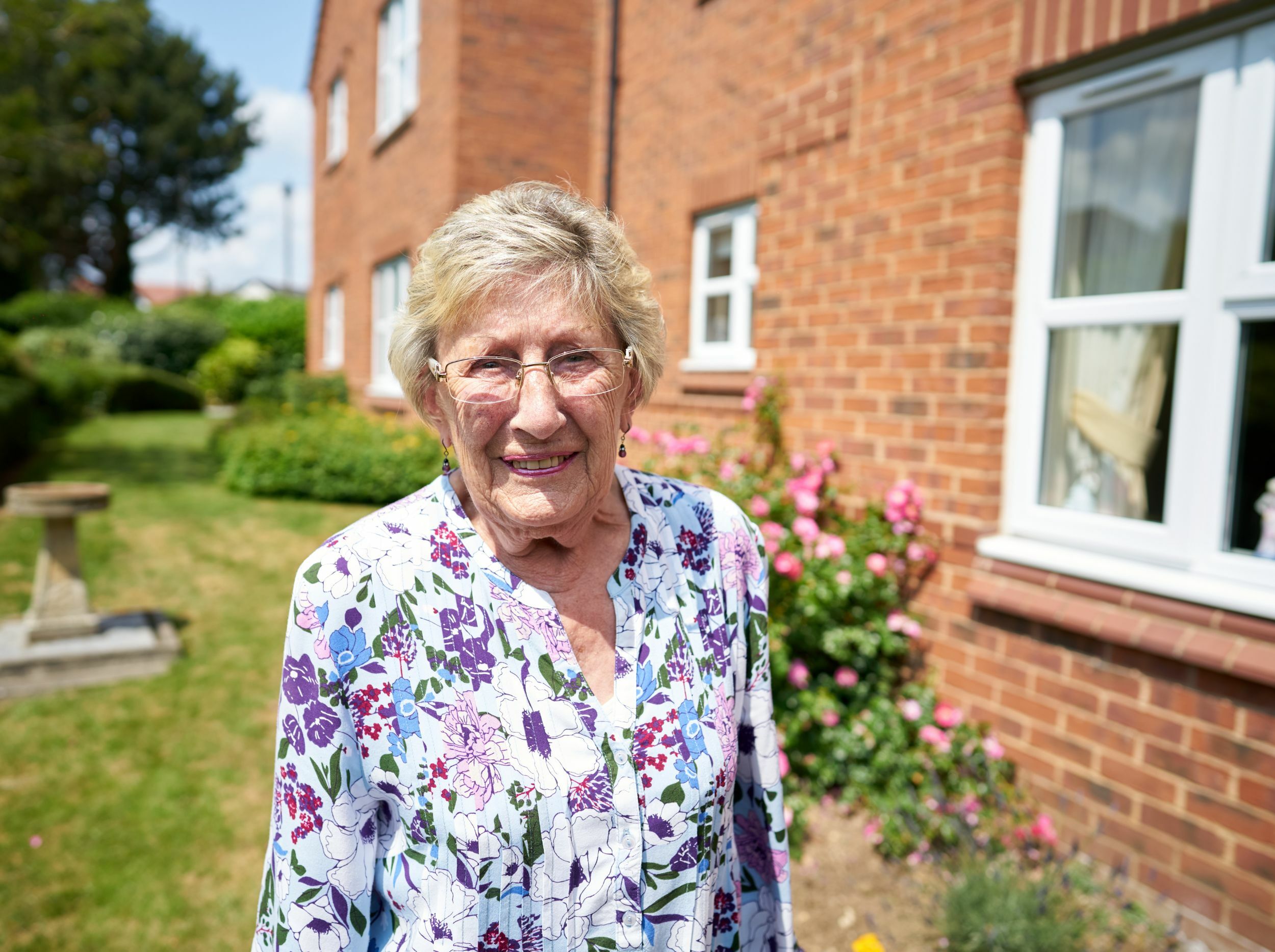 Smiling woman standing in a garden area