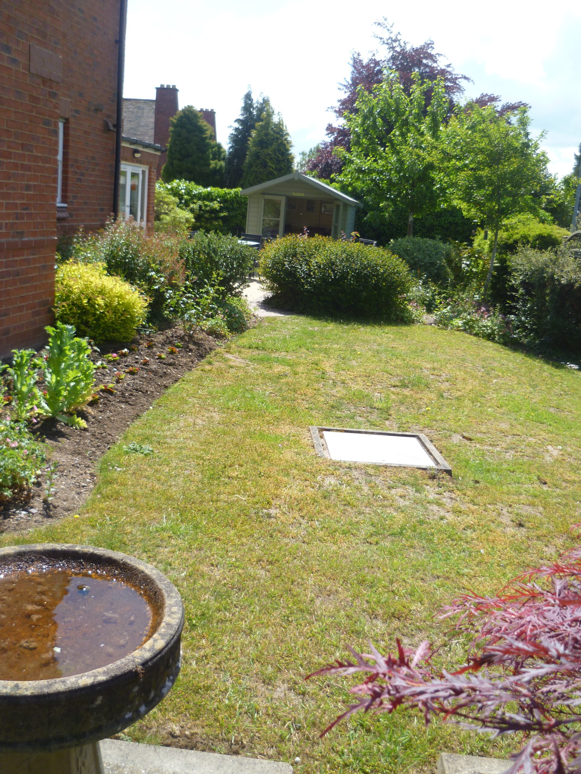 Well-maintained garden area with shrubs and a gazebo.