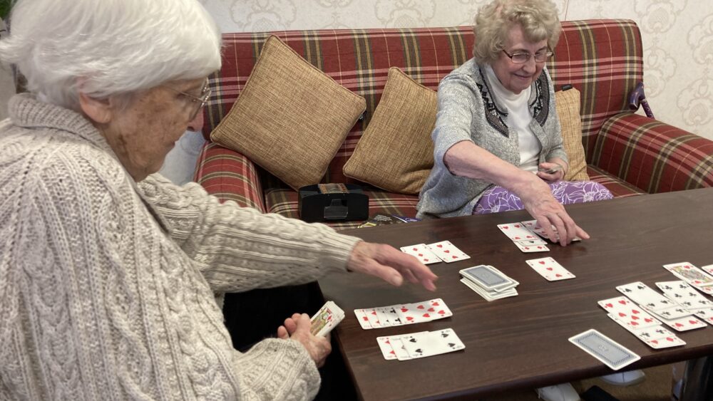 Two seniors playing cards together.