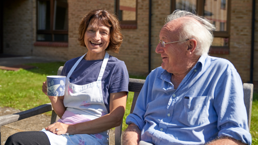 Smiling staff and resident enjoying time outdoors.