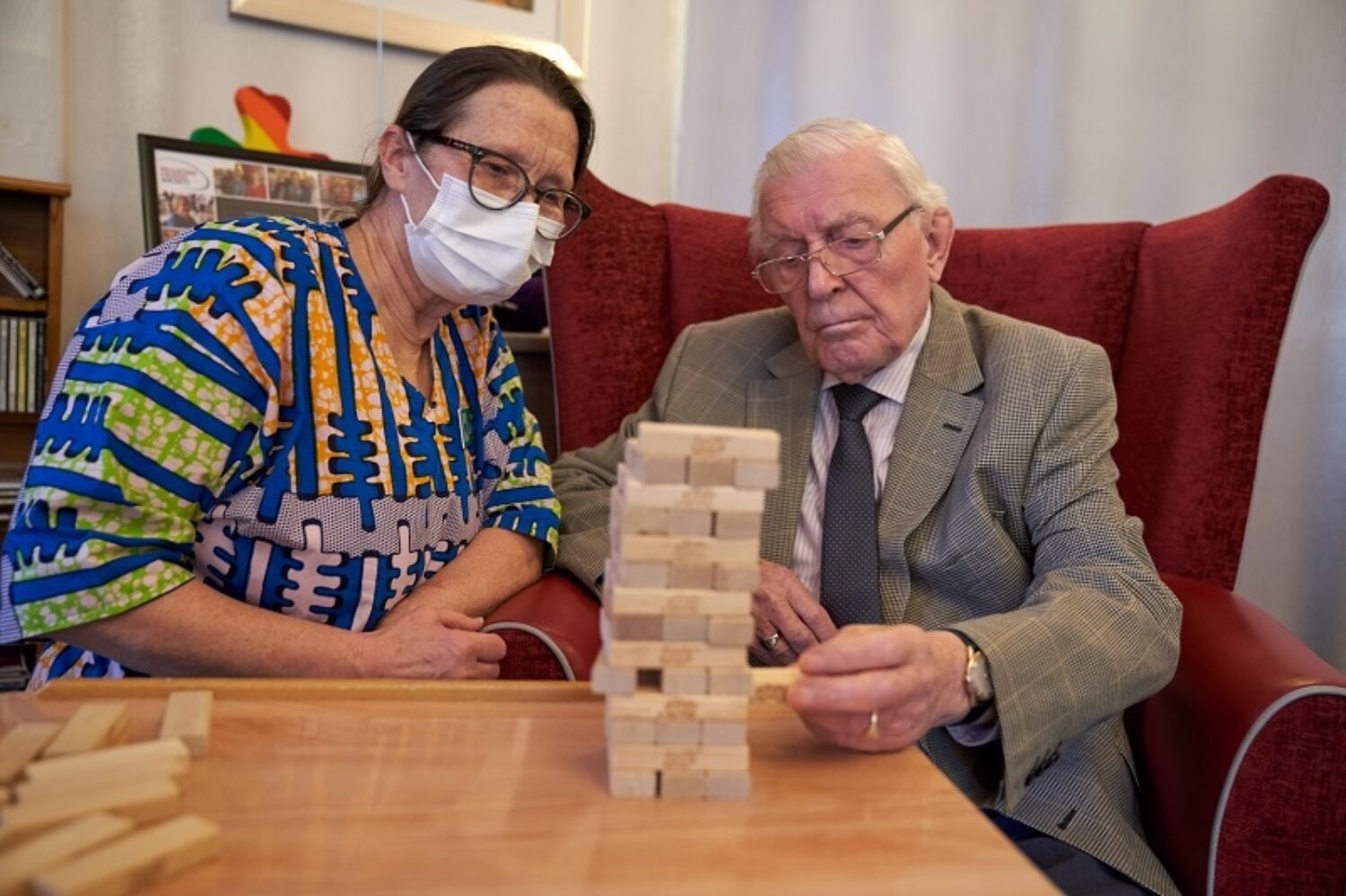 Resident and staff member playing a game indoors.
