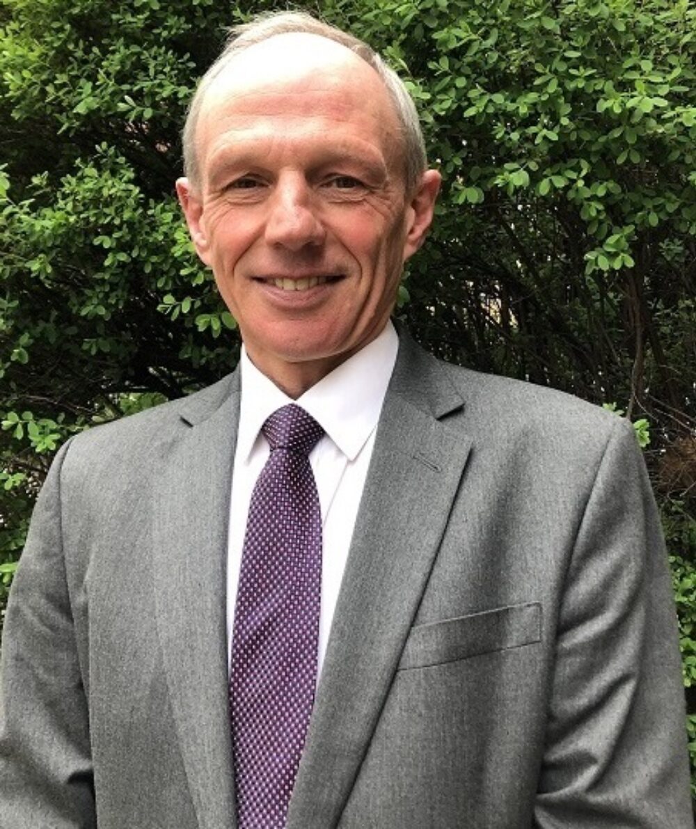 Smiling man in a suit standing outdoors