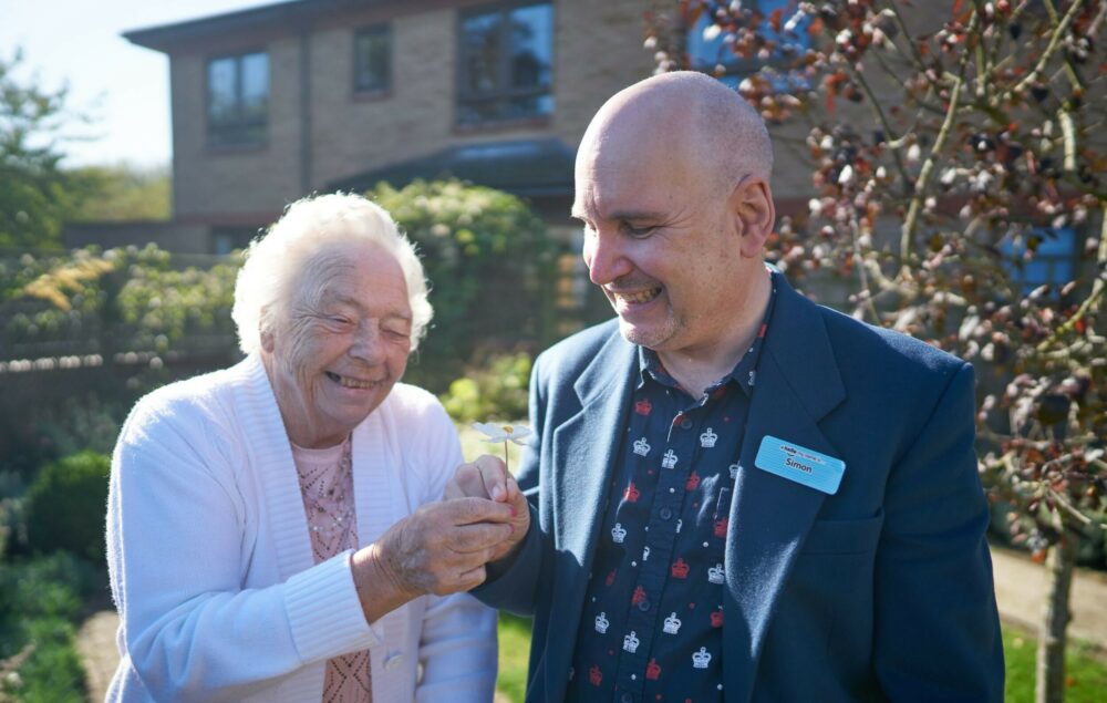 Resident and staff member enjoying time outside together.