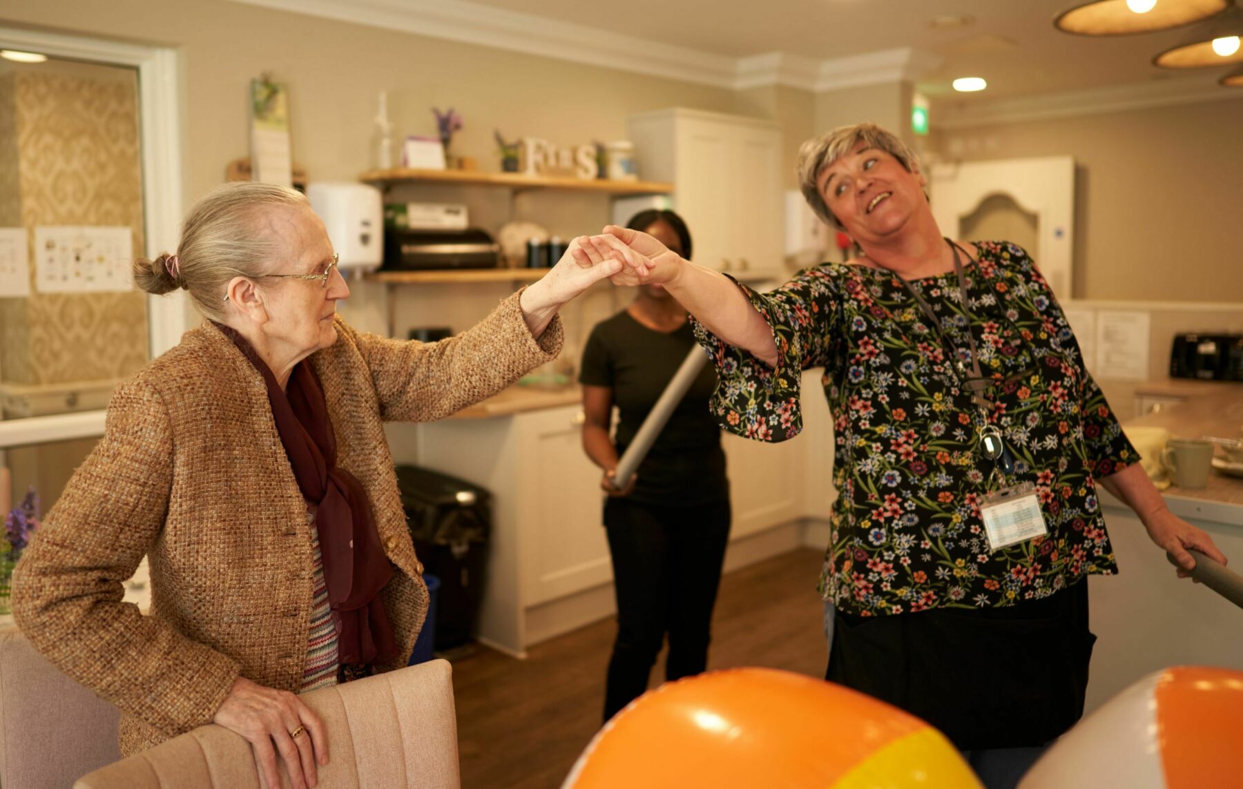 Residents and staff engaging in a joyous activity indoors.