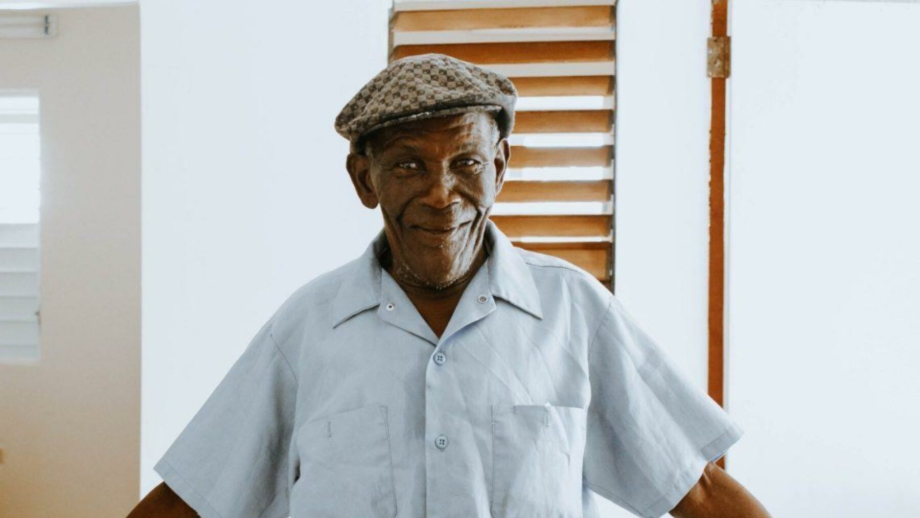 Smiling elderly man in a facility interior.