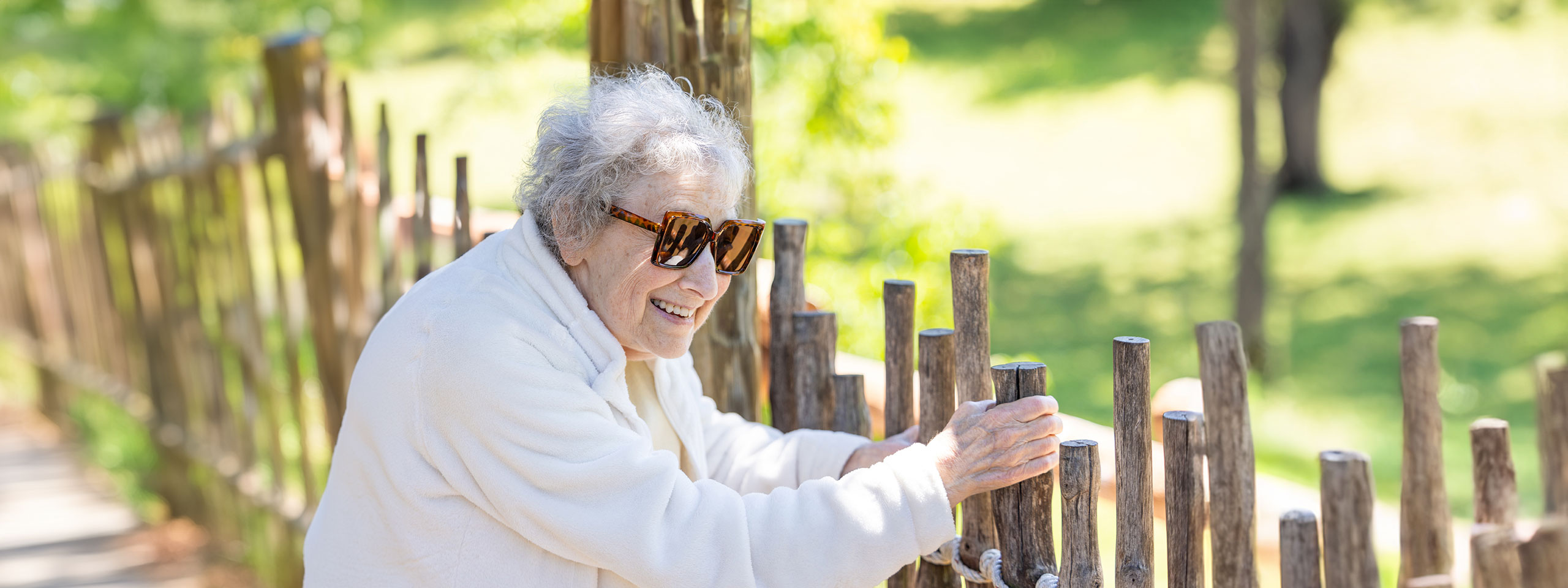 An elderly woman enjoying the outdoors at a senior living facility