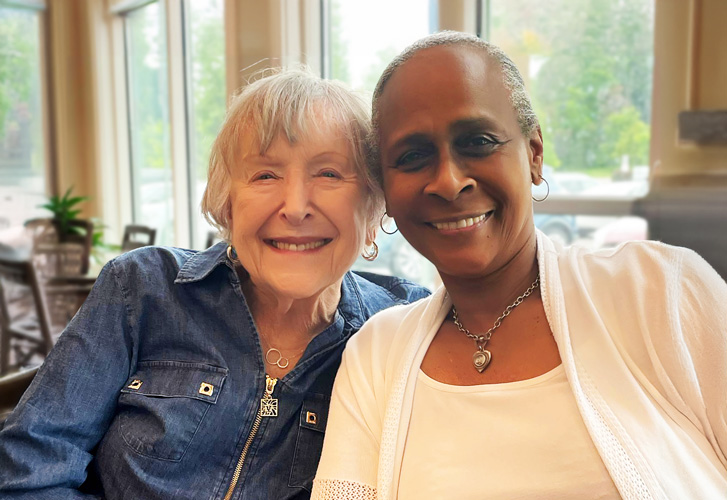 Two residents smiling together in a cozy common area