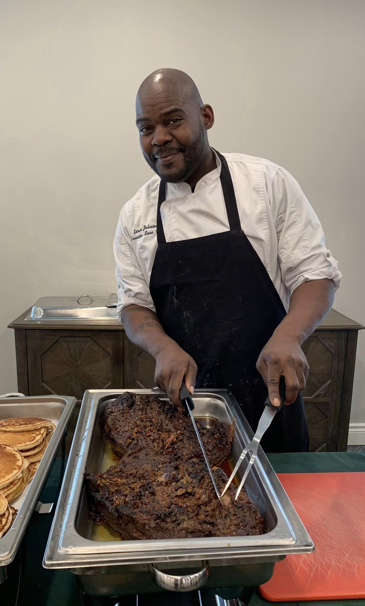 Chef preparing a large roast in the dining area