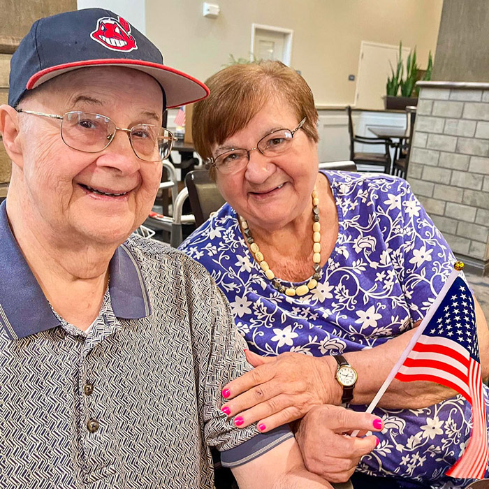 Two residents smiling with an American flag