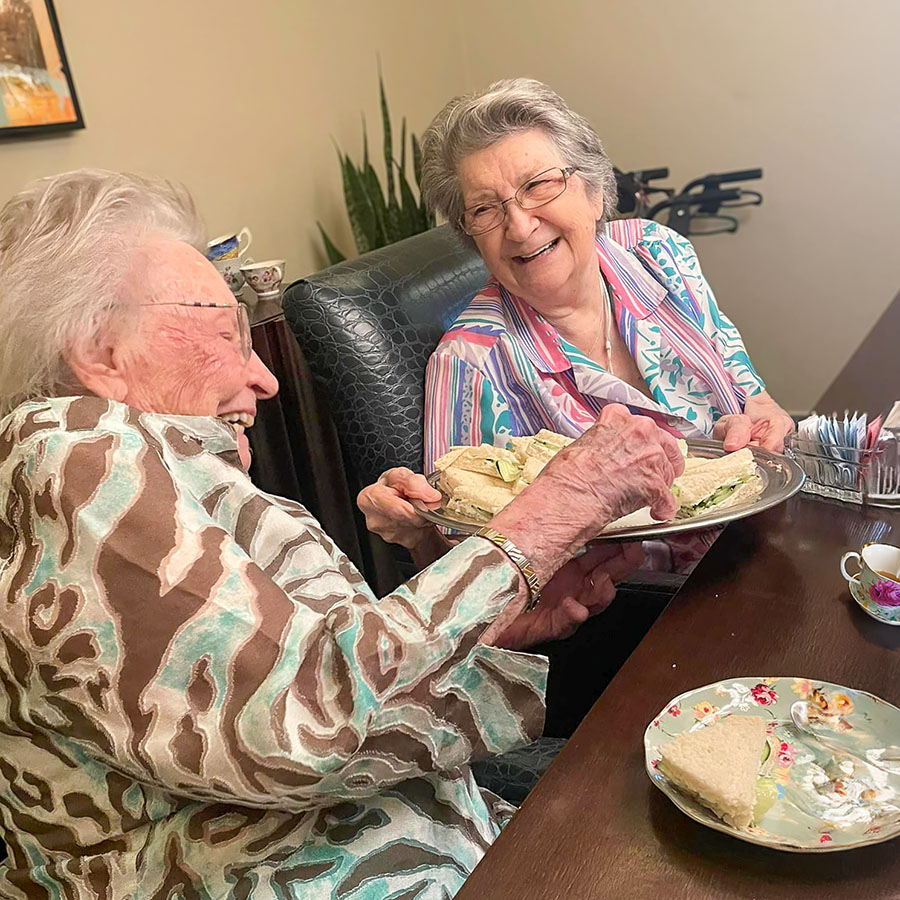Two residents enjoying food in a dining setting