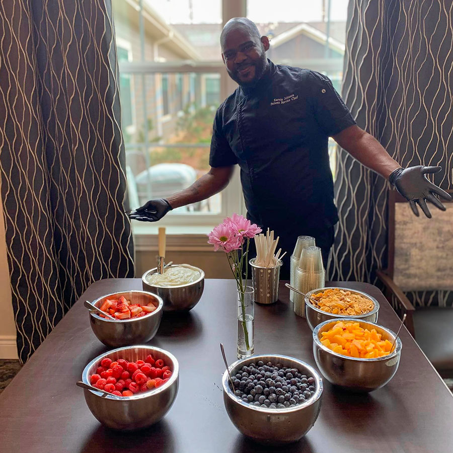 Staff member preparing fruit in a dining area