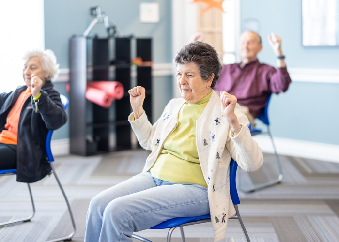 Residents participating in a seated exercise class