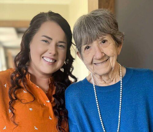 A resident and staff member smiling together