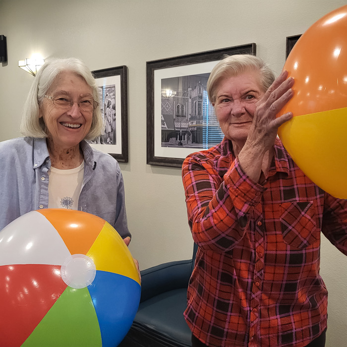 Two residents enjoying beach balls in a common area