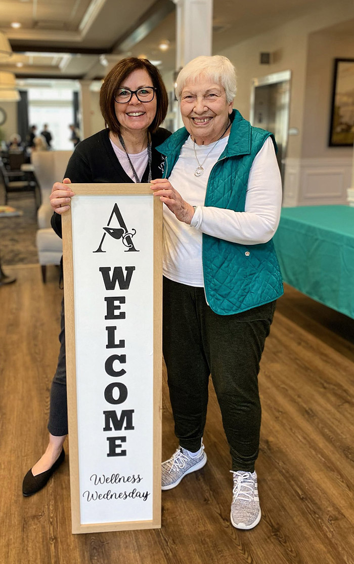 Two women celebrate Wellness Wednesday with a welcome sign