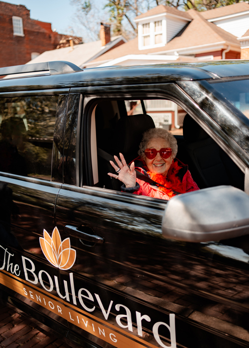 Resident waving from a facility transport van