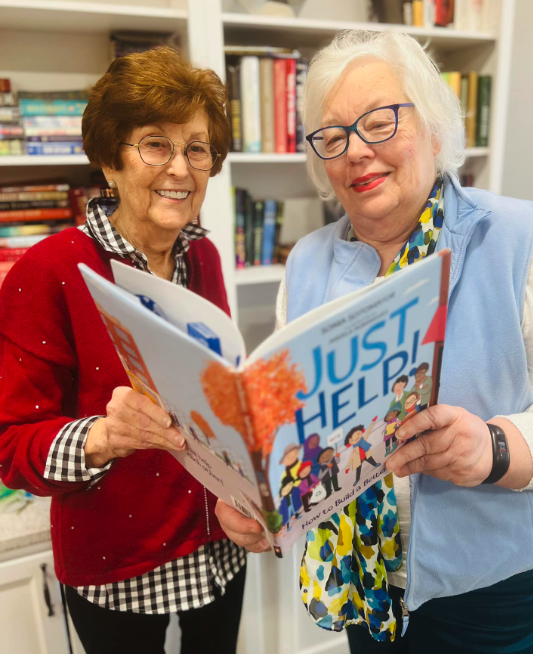 Two residents reading a book in a library setting