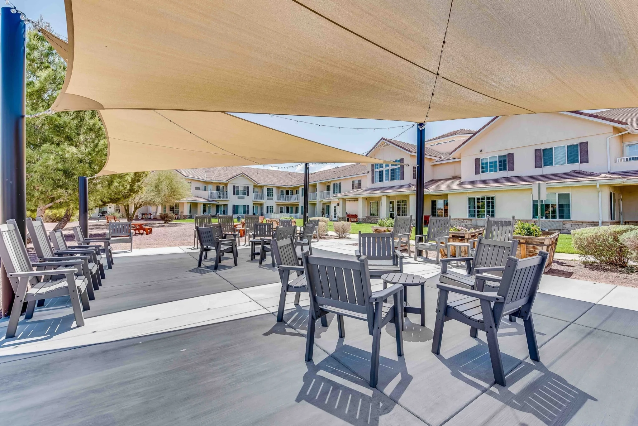 Outdoor seating area with shade and building in background