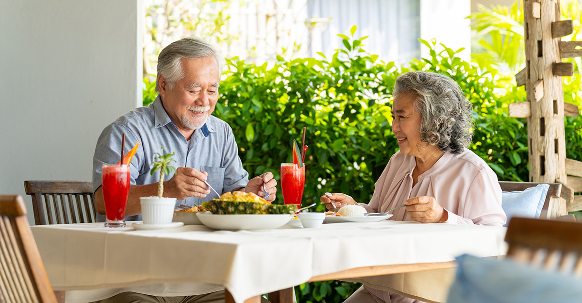 Two residents enjoying a meal outdoors with drinks