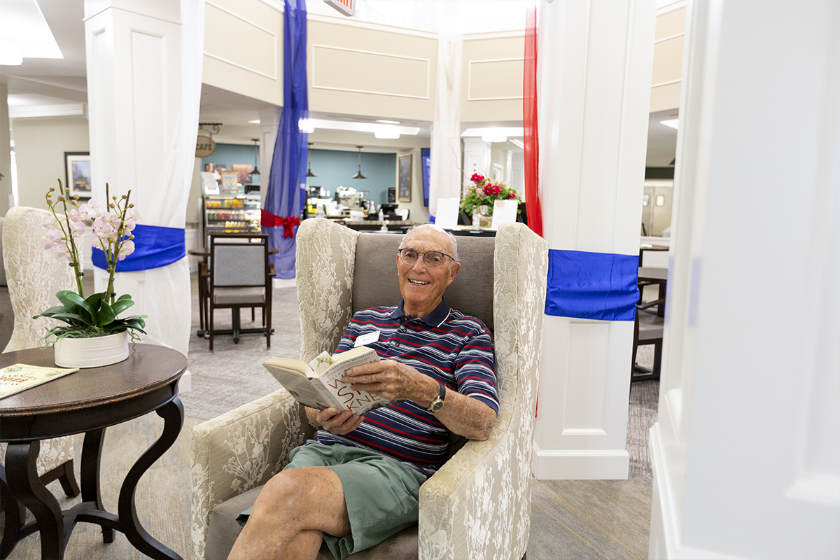 Resident enjoying a book in a cozy common area