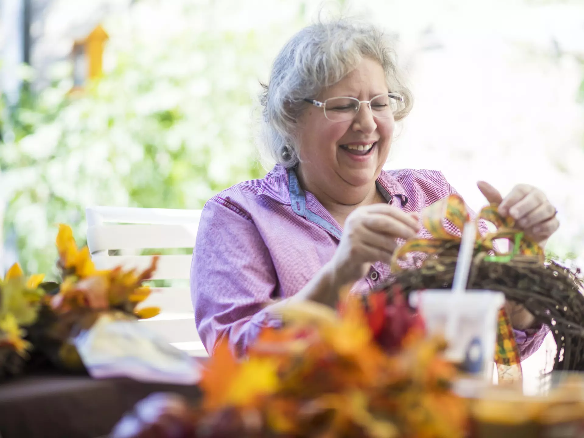 Woman crafting with autumn decorations outdoors
