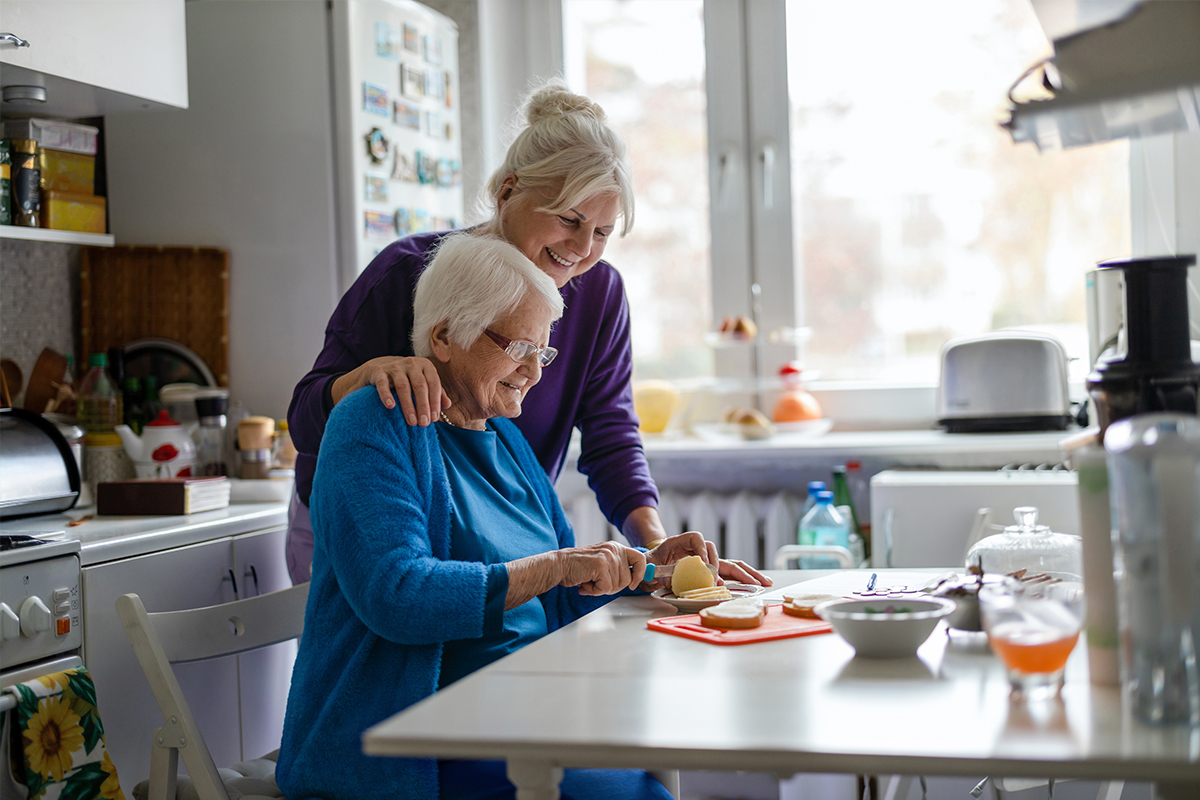 Caregiver helping senior in a kitchen setting