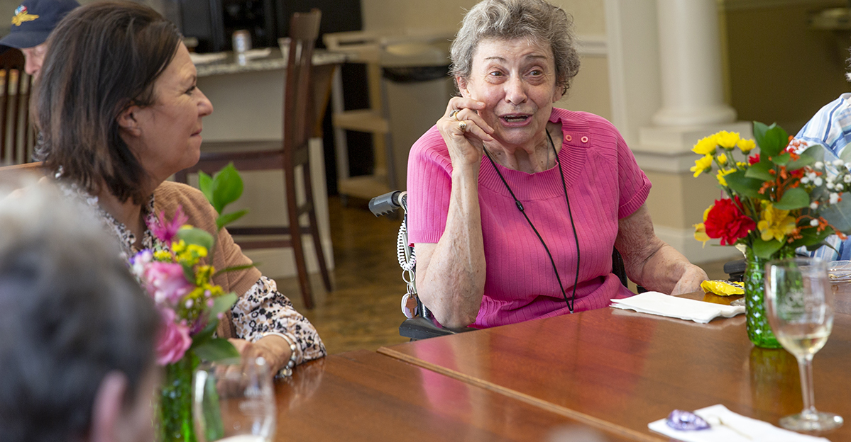 Residents engaging in conversation around a table