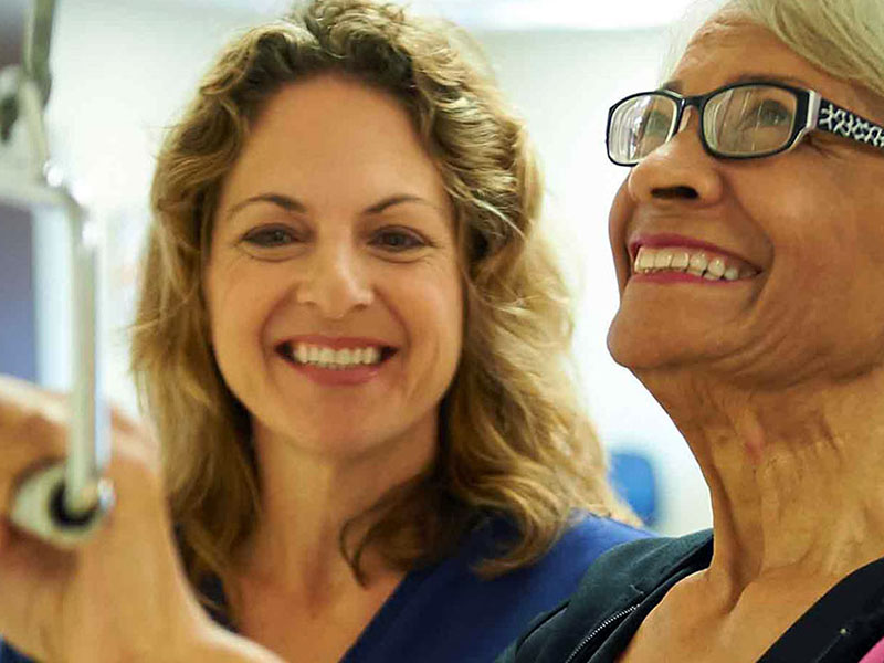 Staff member assisting a resident with a smile