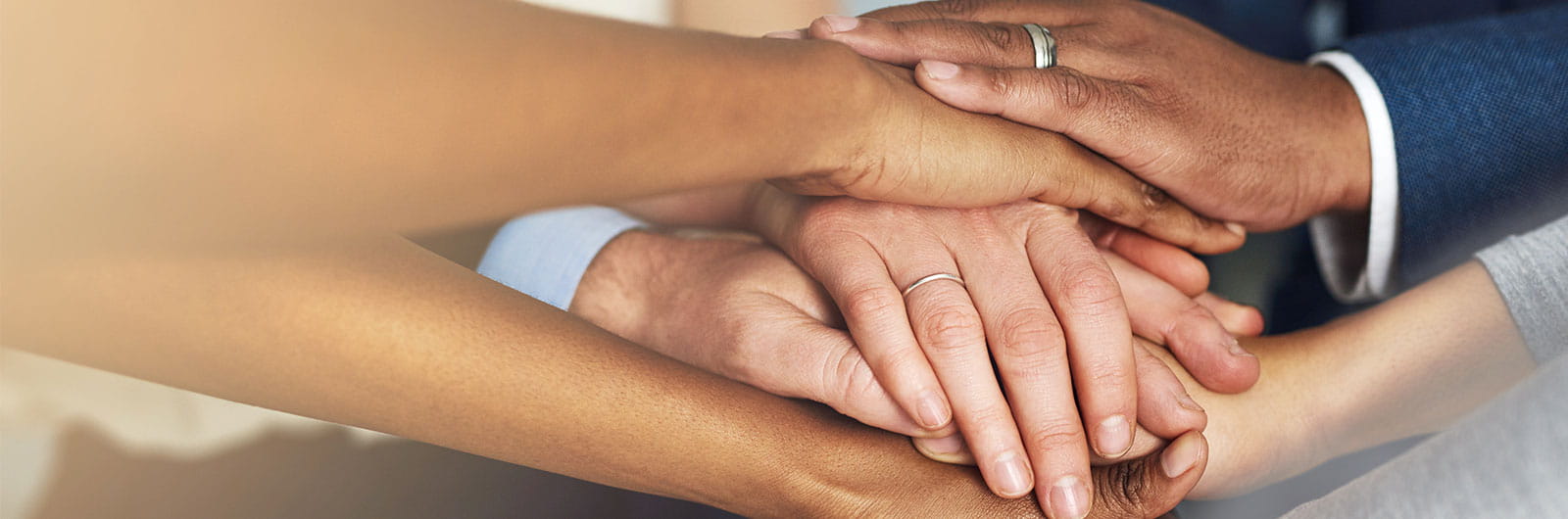 Multiple hands joined together symbolizing unity