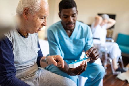 A caregiver assisting a senior resident with medication