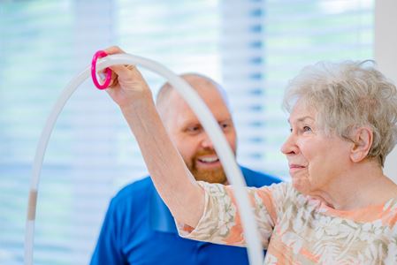 Senior resident engaging in a group activity with staff