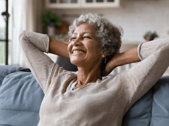A smiling senior woman relaxing indoors on a couch