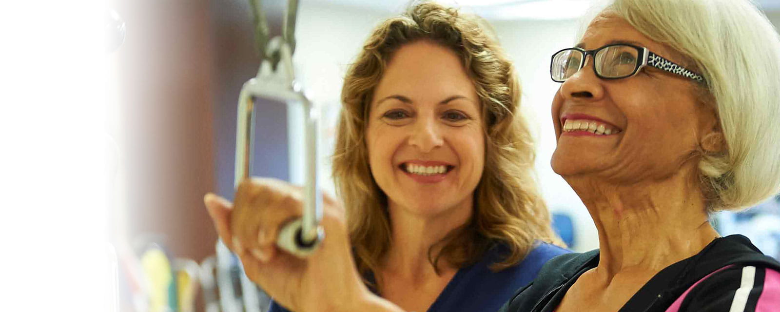 A staff member assisting a resident with therapy equipment