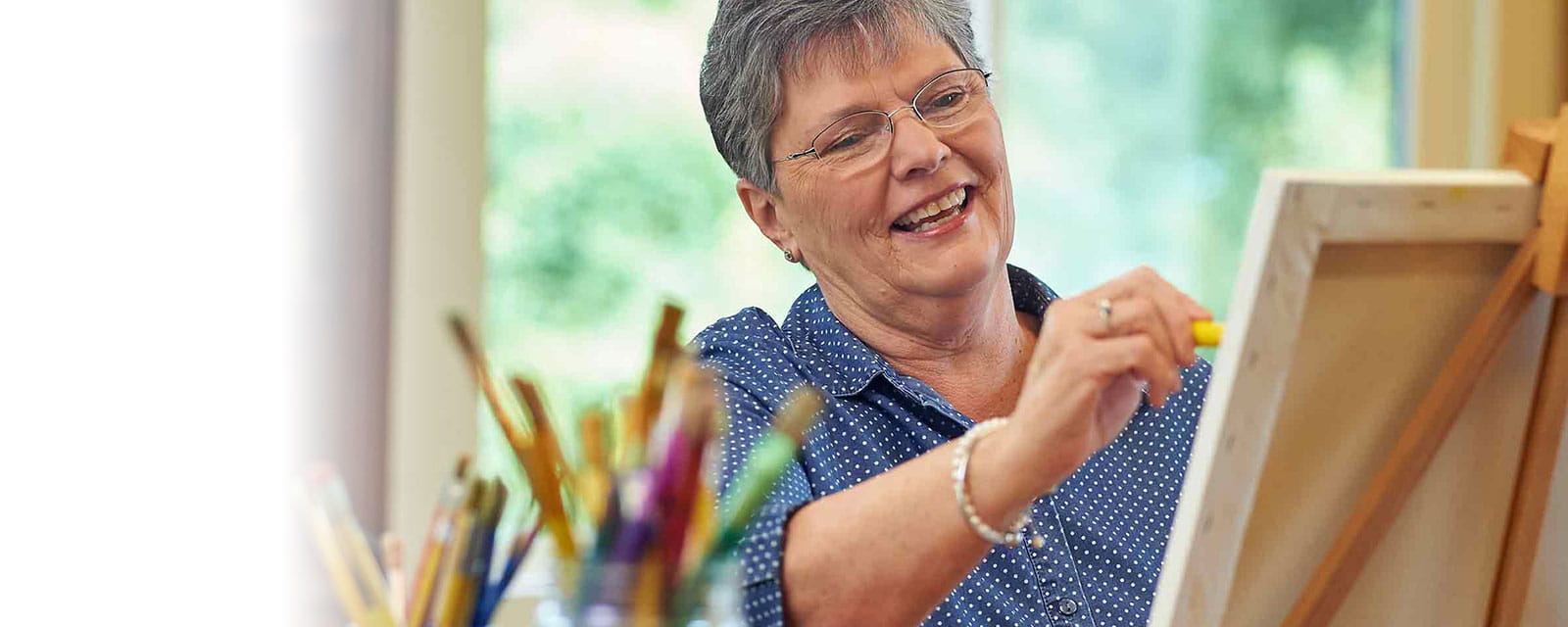 Resident painting in a bright activity room
