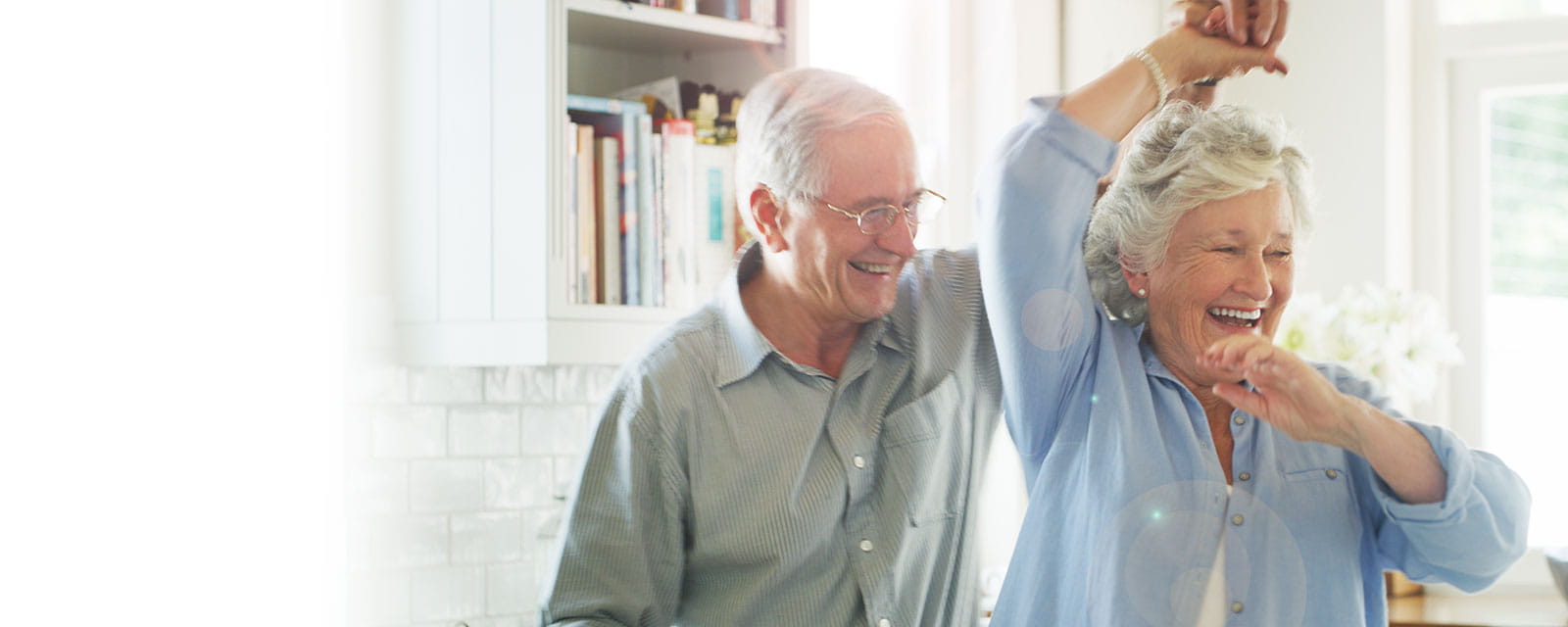 Couple dancing joyfully in a cozy kitchen