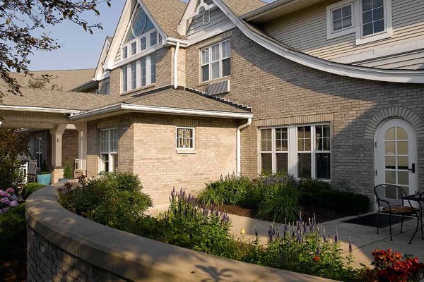 Exterior view of a senior living facility with gardens