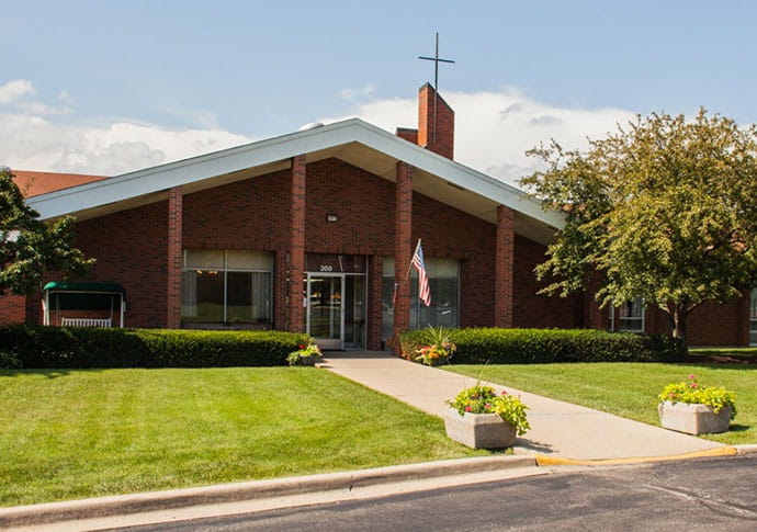 Exterior view of a senior living facility with lush landscaping