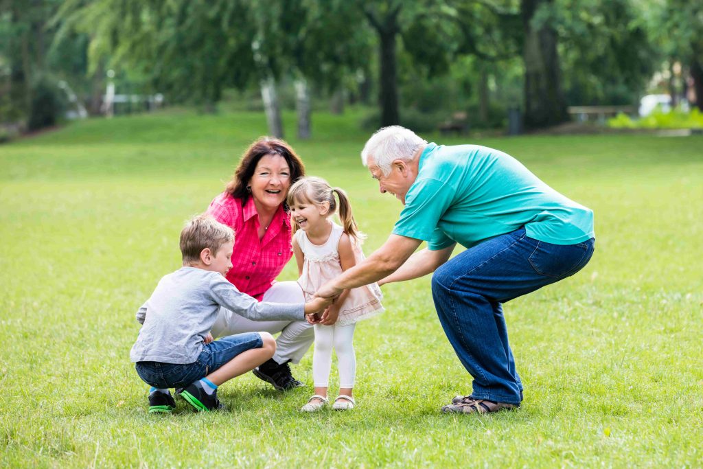 Grandparents playing with children in a park
