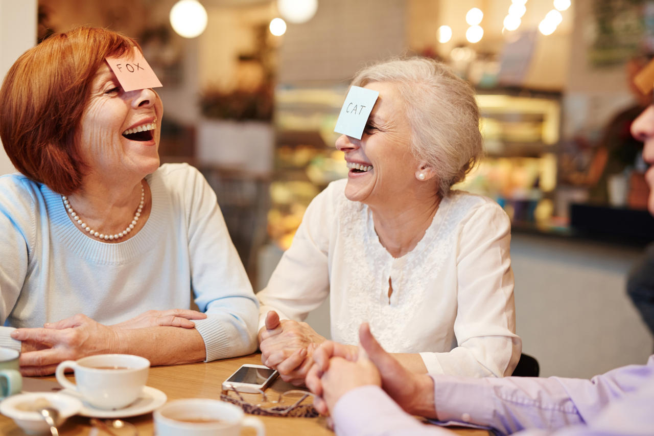 Seniors playing a game and laughing in a common area