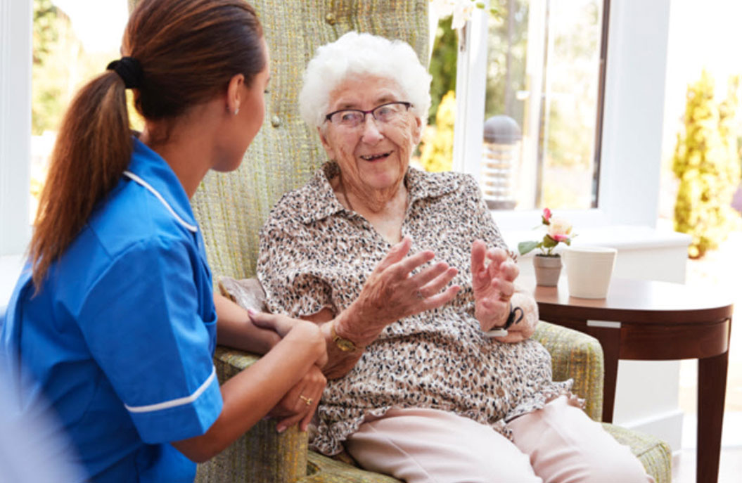 Staff member engaging with a resident in a cozy setting