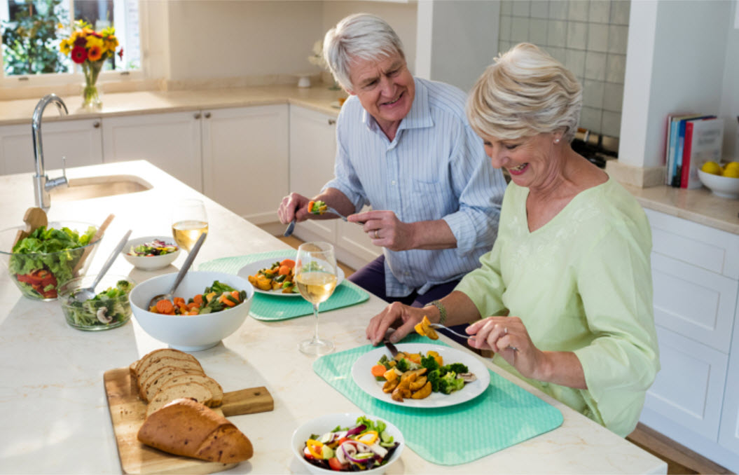 Seniors enjoying a meal together in a bright kitchen