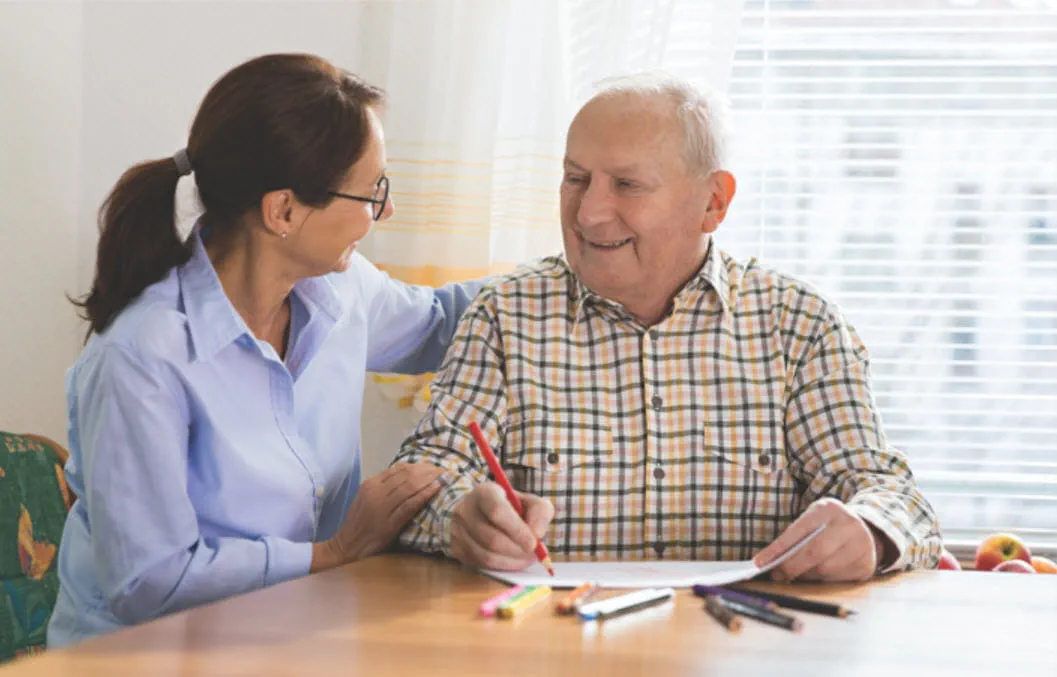 A caregiver and resident engaged in a friendly activity