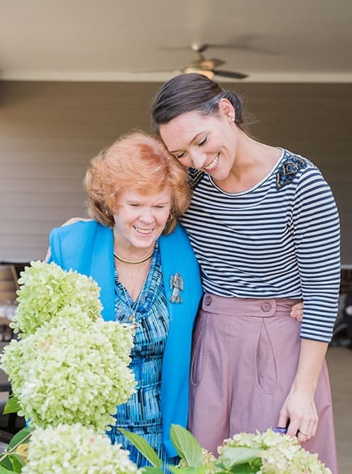 Two women joyfully interacting in a garden setting