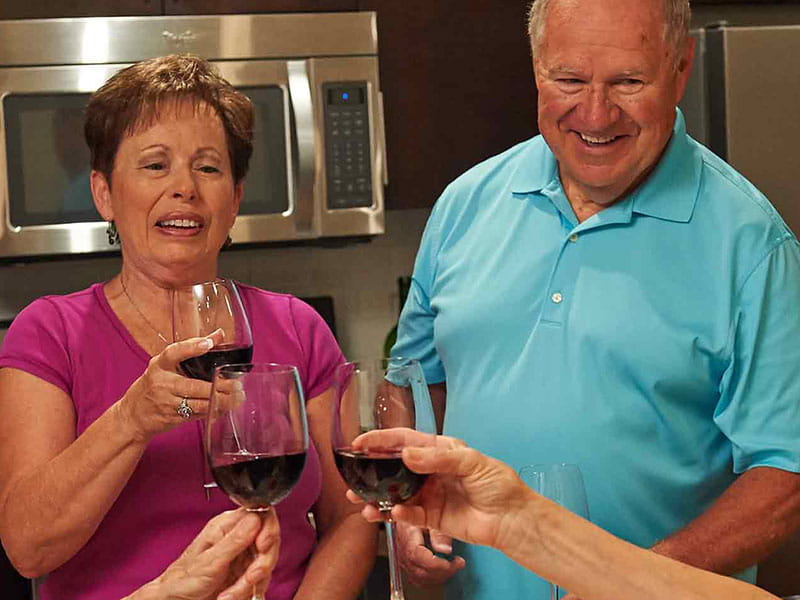 Residents toasting with glasses of wine in a common area