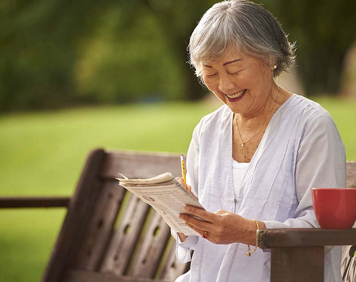 Senior woman enjoying reading outdoors