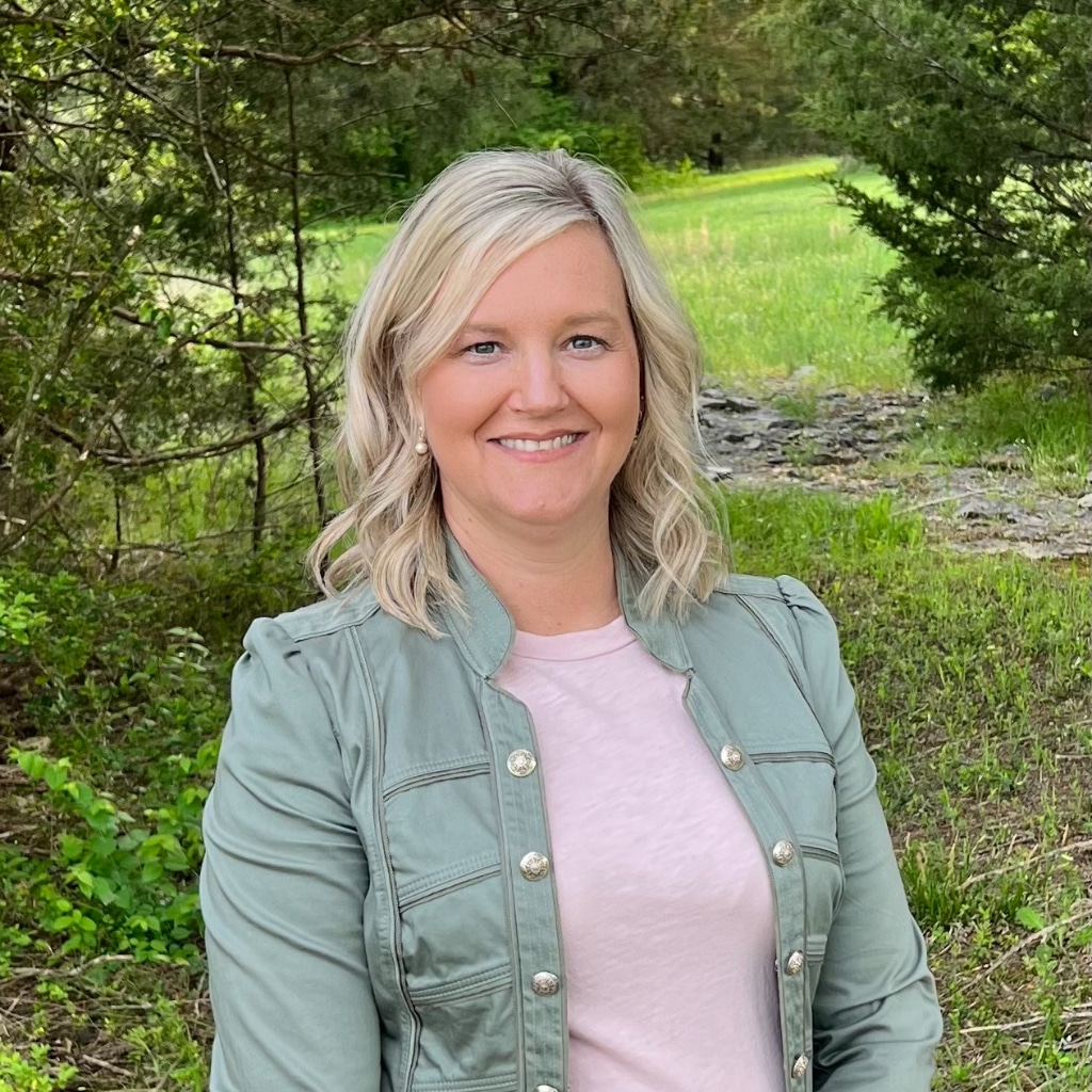 Smiling woman outdoors in a green area