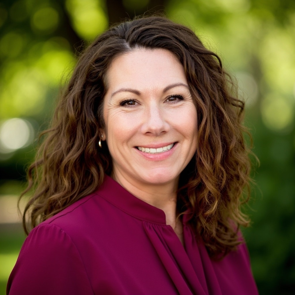 Smiling woman with curly hair in a burgundy top